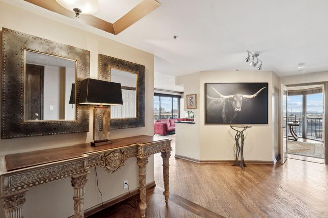 Well lit hallway leading into a modern kitchen. | Image 4
