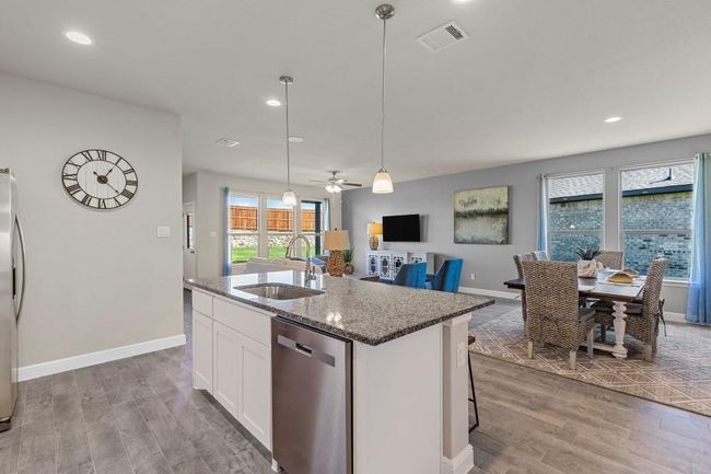 Kitchen featuring stainless steel appliances, wood finished floors, an island with sink, ceiling fan, and recessed lighting | Image 8