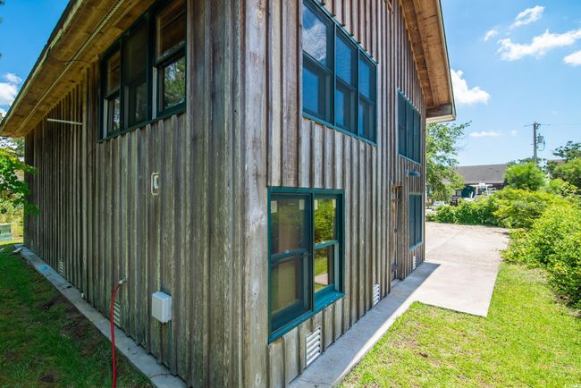 View of side of property with board and batten siding, a patio, and a lawn | Image 5