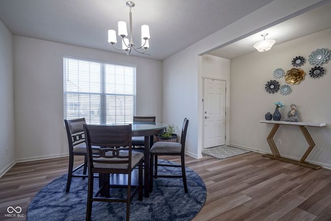 dining area featuring baseboards, a notable chandelier, and wood finished floors | Image 6