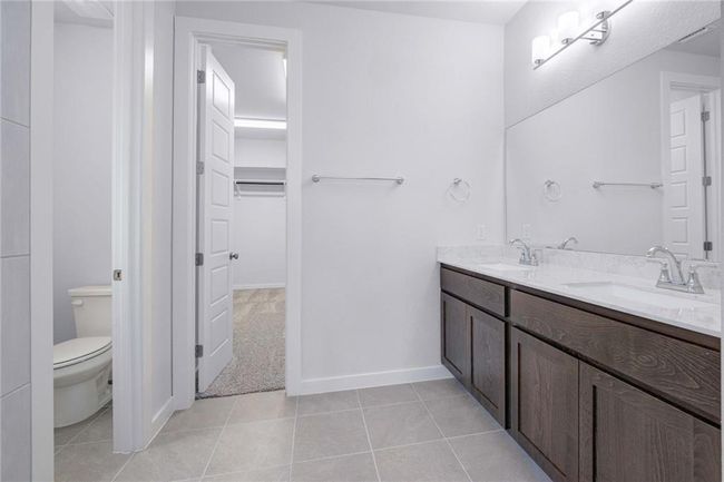 Bathroom with double vanity, stylish flooring | Image 13