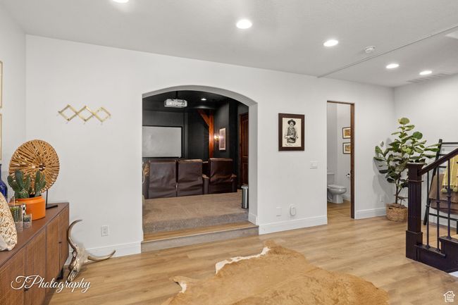 Corridor featuring arched walkways, stairway, wood finished floors, recessed lighting, and baseboards | Image 41
