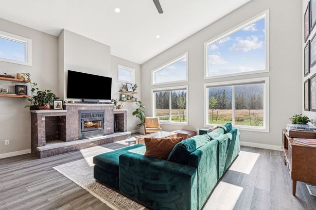 Living area with a brick fireplace, wood finished floors, baseboards, a towering ceiling, and recessed lighting | Image 14