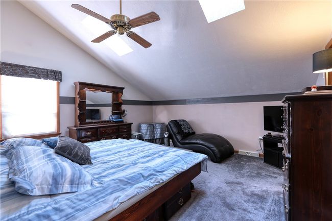 The primary bedroom features a vaulted ceiling with two skylights, an ensuite bath, and a walk-in closet. | Image 13