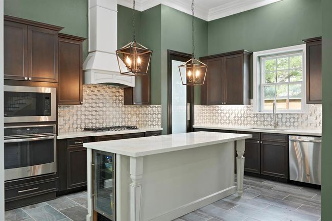 The kitchen has been fully remodeled with a large island with a wine fridge. | Image 6