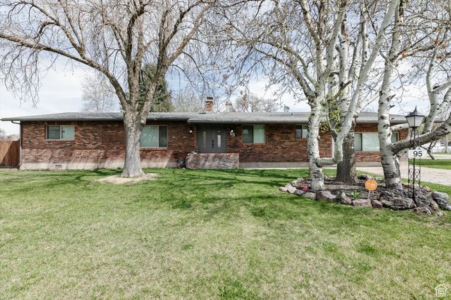 View of front facade featuring a chimney, a front lawn, and brick siding | Image 42