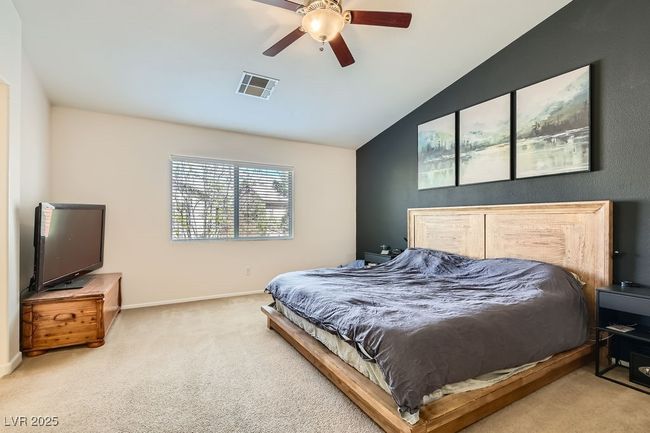 Carpeted bedroom featuring baseboards, visible vents, a ceiling fan, and vaulted ceiling | Image 14