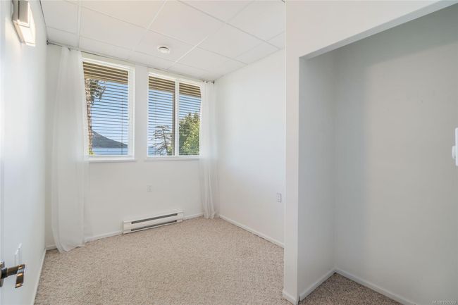 Unfurnished room with a baseboard heating unit, carpet flooring, a drop ceiling, and baseboards | Image 49