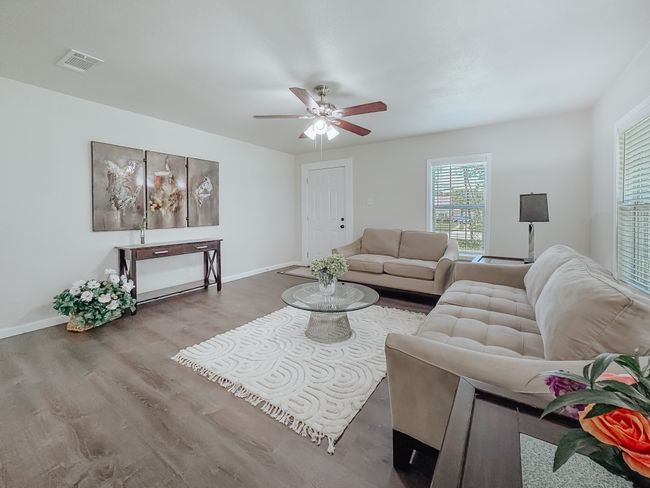 Living area featuring ceiling fan and wood finished floors | Image 5