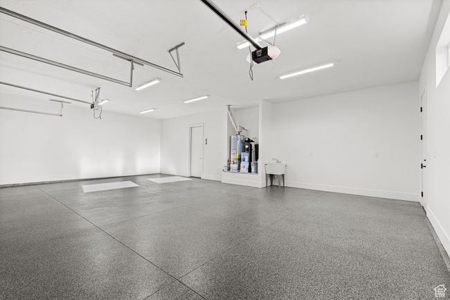 Garage with baseboards, a garage door opener, and gas water heater | Image 28