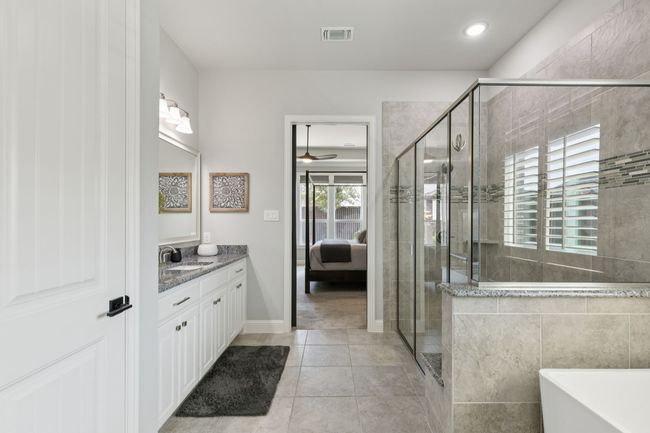 Ensuite bathroom featuring vanity, a soaking tub, a shower stall, tile patterned flooring, and ceiling fan | Image 20