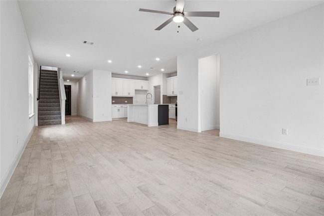 Unfurnished living room featuring stairs, light wood finished floors, recessed lighting, and ceiling fan | Image 30