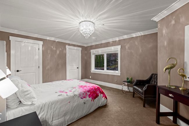 Carpeted bedroom with baseboards, crown molding, and a chandelier | Image 26