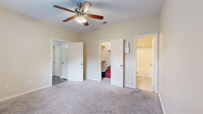 Unfurnished bedroom with connected bathroom, visible vents, baseboards, carpet floors, and a spacious closet | Image 20
