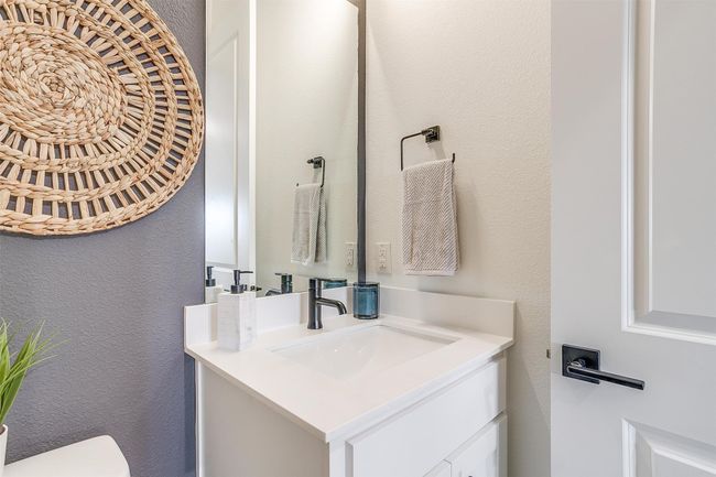 Half bathroom with toilet, vanity, and a textured wall | Image 16
