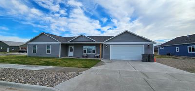 Ranch-style home with central AC, a front yard, and a garage | Image 2