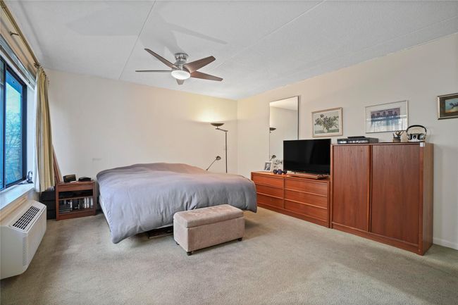 Carpeted bedroom with ceiling fan and a wall mounted air conditioner | Image 20
