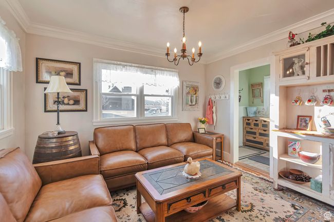 Living room with an inviting chandelier and ornamental molding | Image 36