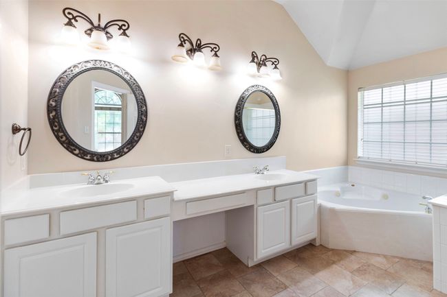 Bathroom with lofted ceiling, a bath, and double vanity | Image 18