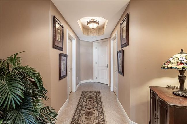 Hallway with a raised ceiling and light tile patterned floors | Image 10