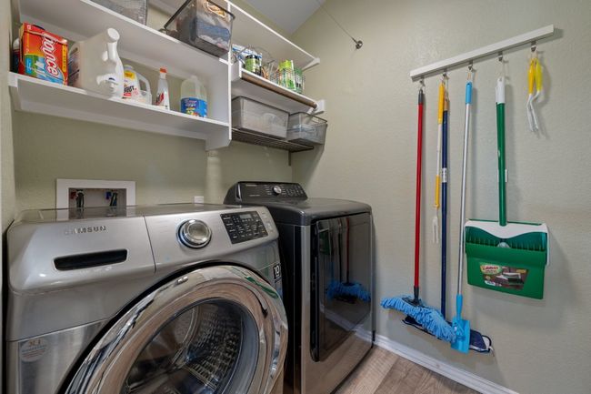 Laundry area featuring laundry area, wood finished floors, baseboards, and washer and clothes dryer | Image 19