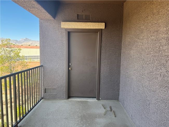 Entrance to property featuring a balcony, stucco siding, and a mountain view | Image 4