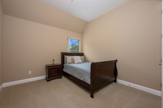 Bedroom with light colored carpet and lofted ceiling | Image 28