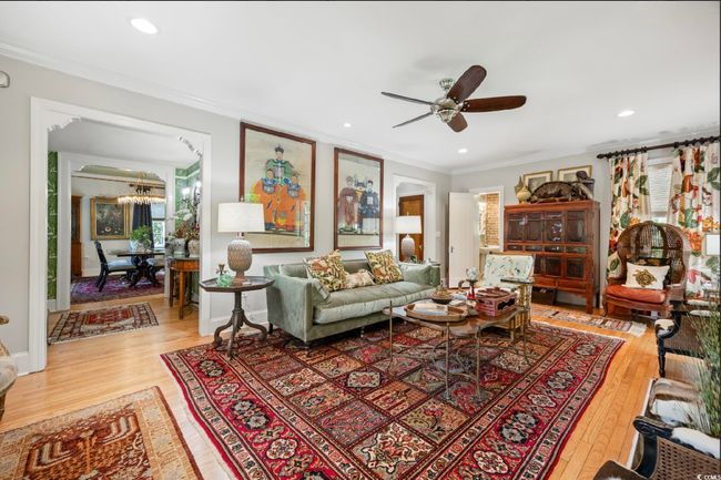 Living room with crown molding, wood-type flooring, ceiling fan, a chandelier, and recessed lighting | Image 33