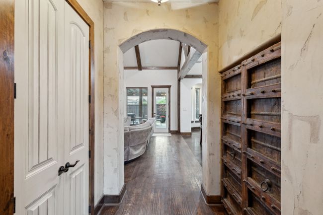 Hallway featuring baseboards, vaulted ceiling with beams, dark wood-style floors, and arched walkways | Image 5