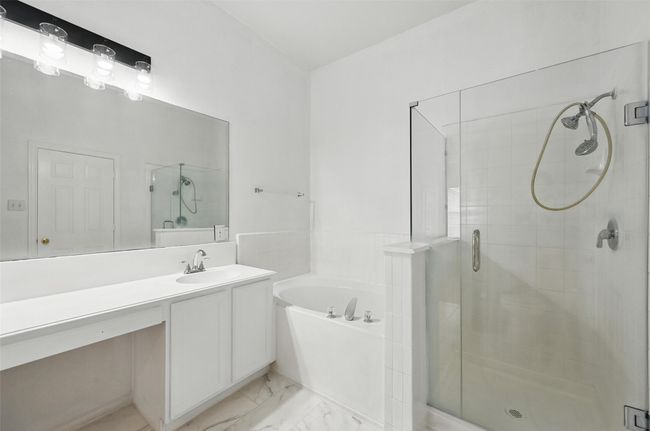 Full bathroom with a stall shower, vanity, a garden tub, and marble finish floors | Image 22
