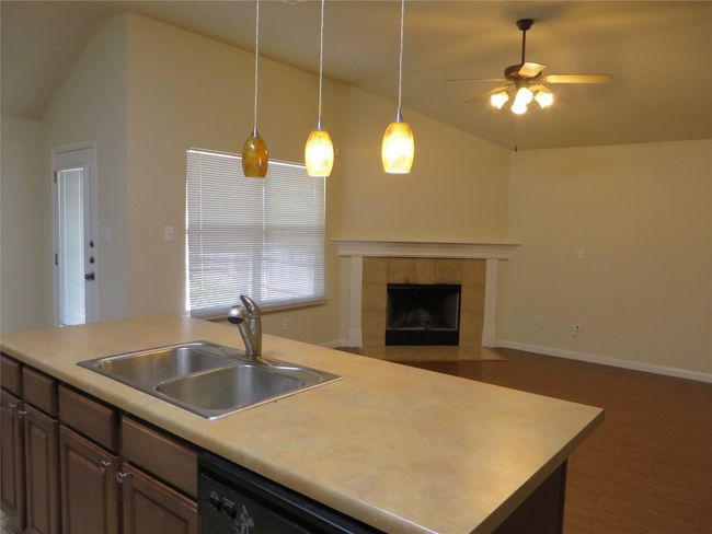 Kitchen with a sink, lofted ceiling, dishwasher, wood finished floors, and a ceiling fan | Image 6