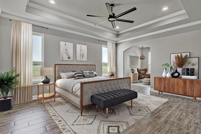 Bedroom featuring a raised ceiling, arched walkways, light wood-type flooring, ornamental molding, and recessed lighting | Image 17