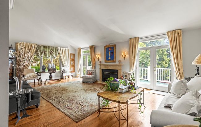 Living area featuring a fireplace with flush hearth, wood finished floors, and french doors | Image 10