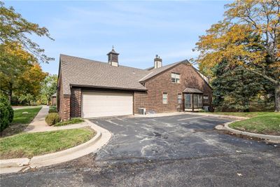 View of front of home with a front yard, central AC, and a garage | Image 2