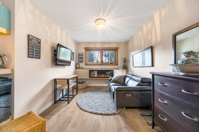 Living area featuring a glass covered fireplace, baseboards, and light wood-style floors | Image 16