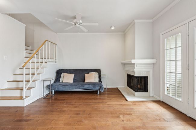 Living area featuring stairway, wood finished floors, and a healthy amount of sunlight | Image 10