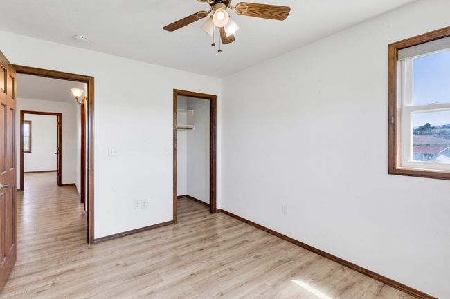 bedroom featuring light wood finished floors, baseboards, a closet, and a ceiling fan | Image 39