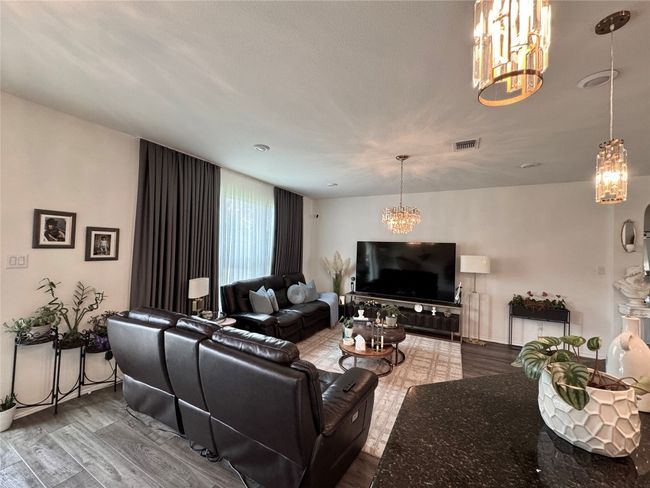 Living area featuring a chandelier and wood finished floors | Image 15