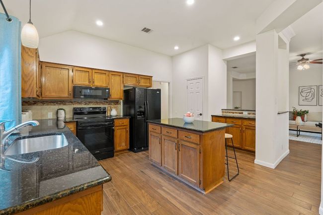 The kitchen opens to the living room through a carved opening making it easy to stay connected while preparing meals. | Image 15