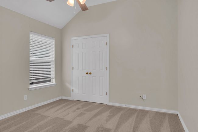 Unfurnished bedroom featuring carpet, lofted ceiling, a closet, and ceiling fan | Image 29