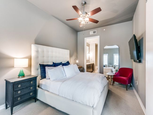 Bedroom featuring light carpet, baseboards, ceiling fan, and arched walkways | Image 5