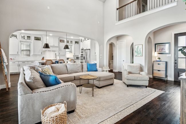 Living room featuring dark wood-style flooring, arched walkways, and baseboards | Image 10