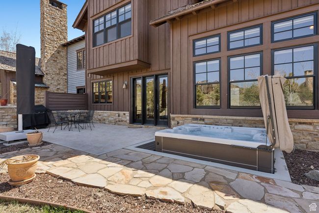 Rear view of house with an outdoor hot tub, outdoor dining area, and a patio area | Image 35