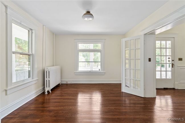 Spare room featuring radiator, wood finished floors, and baseboards | Image 7