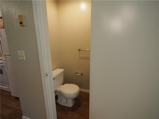 Bathroom featuring wood finished floors, toilet, and baseboards | Image 5