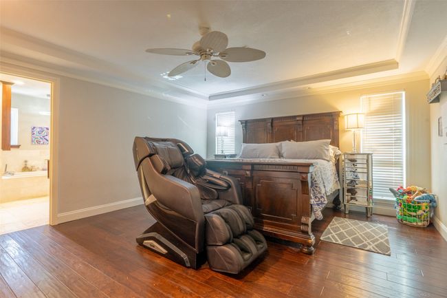 Bedroom with a raised ceiling, hardwood / wood-style floors, ensuite bathroom, and ornamental molding | Image 14