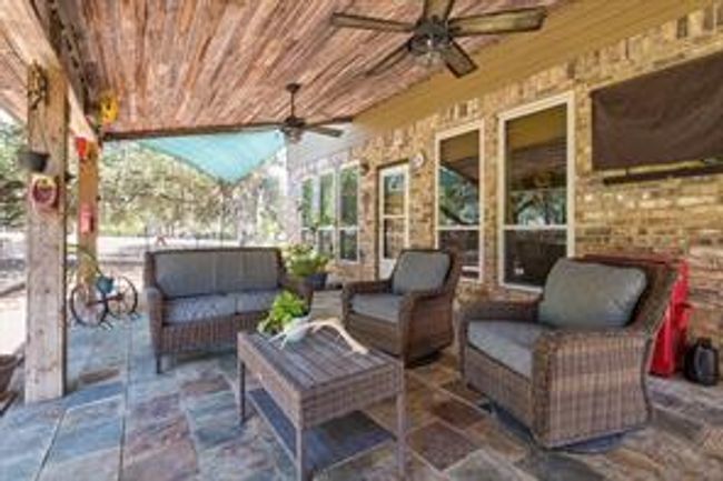 View of patio with an outdoor hangout area and a ceiling fan | Image 34