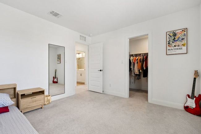 Carpeted bedroom with a walk in closet and connected bathroom | Image 19