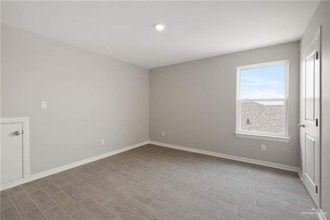 Spare room featuring wood finished floors, baseboards, and recessed lighting | Image 10