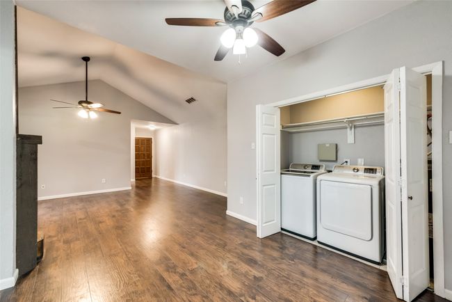 Laundry area with a ceiling fan, washing machine and clothes dryer, and dark wood finished floors | Image 5